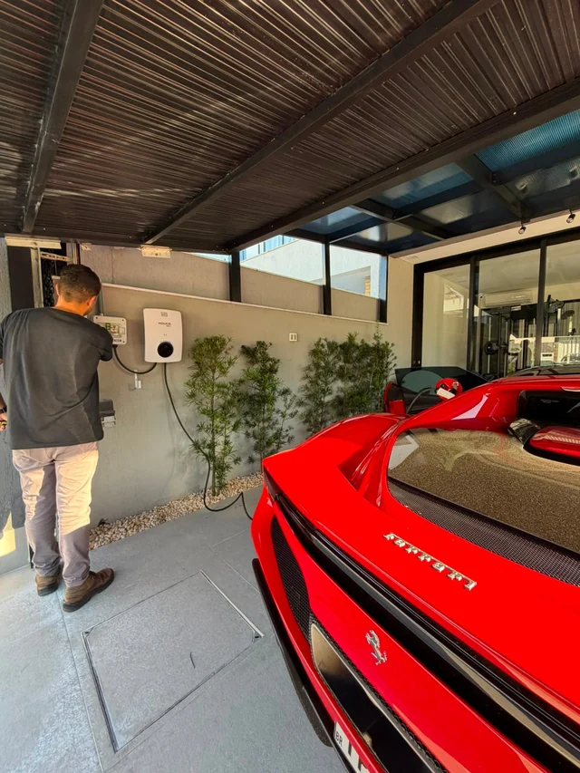 Instalação do carregador ao lado da Ferrari, com quadro de proteção dedicado