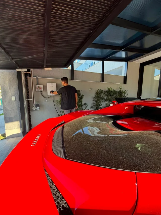 Técnico da Elektroauto conectando o carregador à Ferrari na garagem do cliente